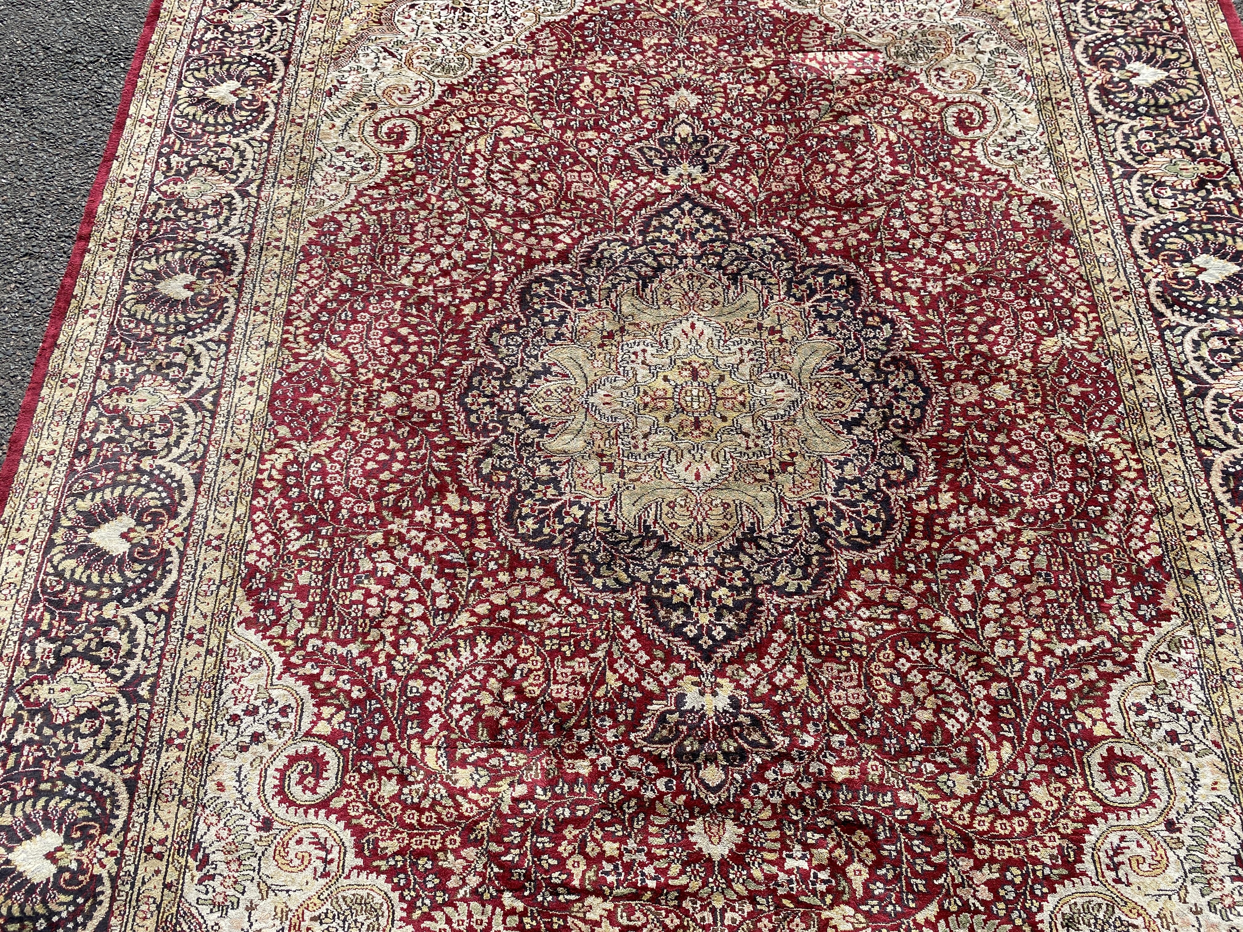 A Kashmiri part silk burgundy ground floral carpet, 330 x 240cm